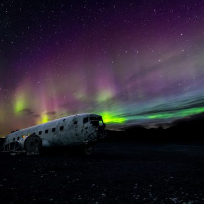 Islande, Solheimasandur. Carcasse d'un avion écrasé, sous une aurore boréale. Photo : Thomas Tucker.